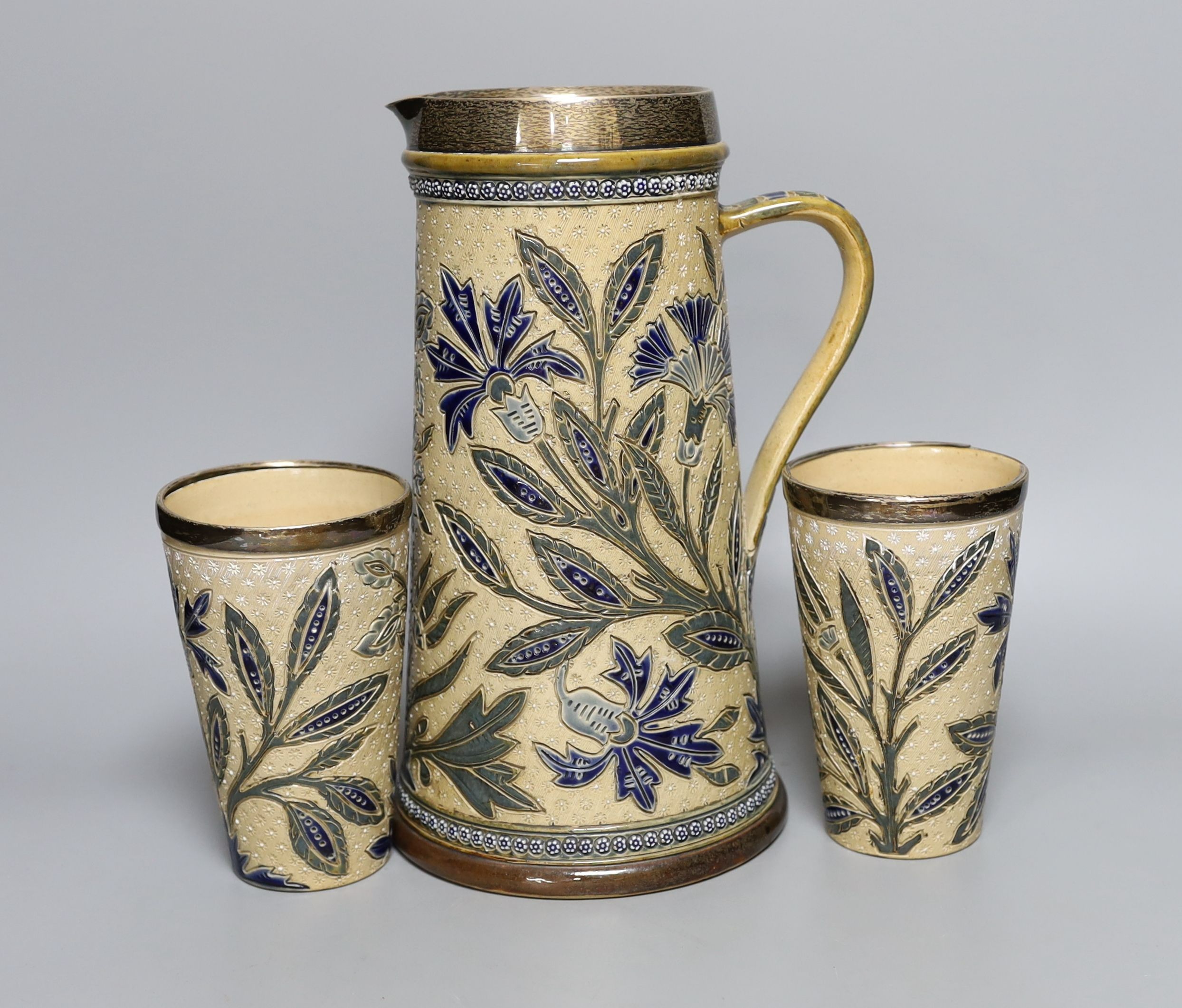 A silver mounted Doulton Lambeth jug by Louisa J Davis, 26.5cm tall, and a pair of matching beakers